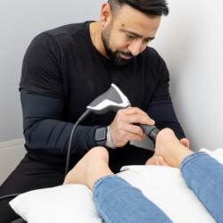 therapist performing foot shockwave therapy in mississauga